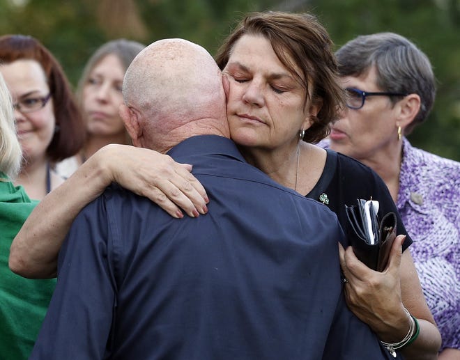 Terry Sullivan, right, whose son Alex was killed on his birthday in the 2012 Aurora movie theatre attack, embraces Lonnie Phillips, whose daughter Jessica Ghawi was also killed, after a jury failed to agree on whether theater shooter James Holmes should get the death penalty Friday, Aug. 7, 2015, in Centennial, Colo. Holmes will be sentenced to life in prison without parole.