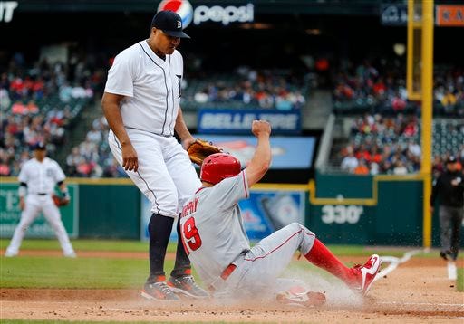 Los Angeles Angels' David Murphy (19) scores as Detroit Tigers starting pitcher Alfredo Simon looks down after throwing a wild pitch to allow the run during the first inning of a baseball game Tuesday, Aug. 25, 2015, in Detroit. (AP Photo/Paul Sancya)