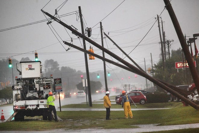 Technicians arrive to survey the damage after power poles were bent over by high winds during a severe thunderstorm along Dr. Martin Luther King, Jr. Boulevard near New Bern Mall on Thursday. Crews were working to restore power to about 1,500 customers, according to the City of New Bern.
