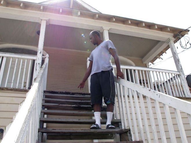 Steven Washington, son of Chevelle Washington, who fled to Houston and still lives there, on the steps of the home the family rode out Hurricane Katrina in in New Orleans. The Associated Press