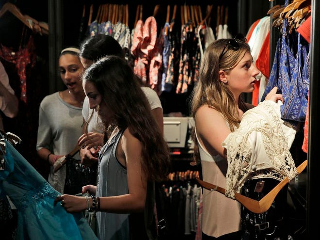 Sofia Harrison, 15, right, and some of her friends browse clothing at a shopping mall in Garden City, New York. Teens aren't roaming around the mall for kicks during back-to-school. They're researching what they want online and following popular hashtags on social media so they can piece together looks before they get there. The Associated Press