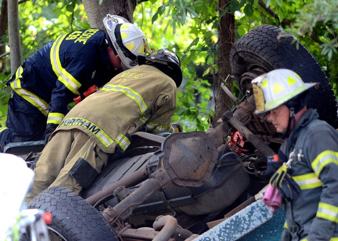 Rescue personnel work at the scene of an overturned pickup truck on Route 206 in Southampton on Aug. 27, 2015, that resulted in two deaths.