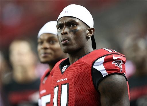 FILE - In this Aug. 14, 2015, file photo, Atlanta Falcons wide receiver Julio Jones (11) watches from the sidelines during the second half of an NFL football preseason game against the Tennessee Titans in Atlanta. As his agent negotiates a new contract with the Falcons, two-time Pro Bowl receiver Julio Jones goes about his business as if nothing has changed. (AP Photo/John Bazemore, File)