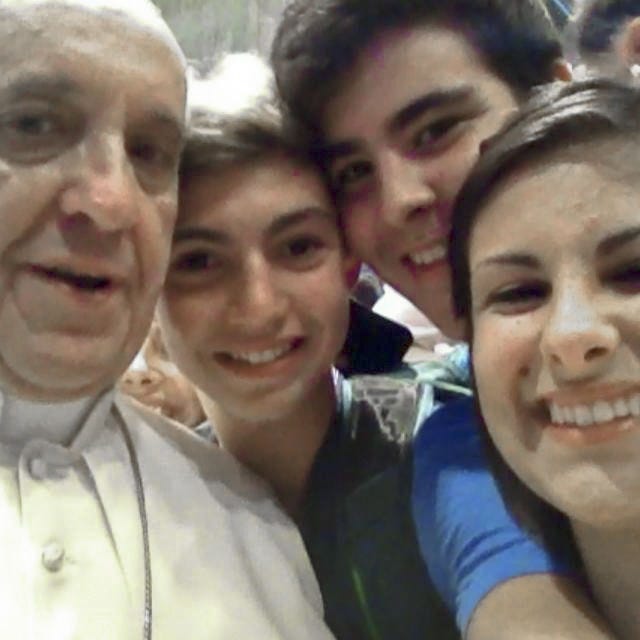 In this Aug. 28, 2013, photo released by Deborah Arcelli, Pope Francis has his picture taken inside St. Peter's Basilica with youths from the Italian Diocese of Piacenza and Bobbio who came to Rome for a pilgrimage.