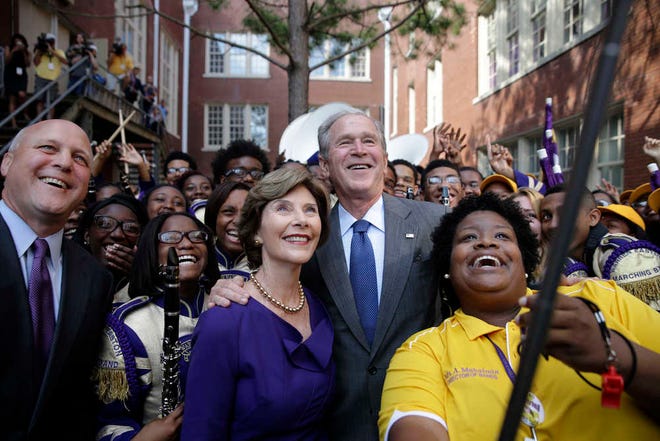 Former President George W. Bush poses for a 'selfie' photo with former first lady Laura Bush, marching band director Asia Muhaimin, right, and New Orleans Mayor Mitch Landrieu, far left, at Warren Easton Charter High School in New Orleans, Friday, Aug. 28, 2015. Bush is in town to commemorate the 10th anniversary of Hurricane Katrina, which is Saturday. (AP Photo/Gerald Herbert)
