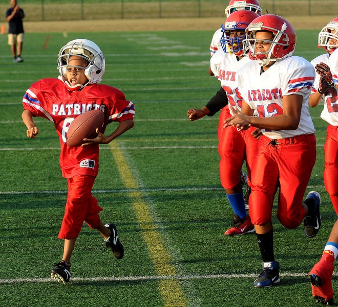 Carmello Anderson, 7, scores a touchdown with his teammates cheering him on Saturday evening at the Westampton Sports Complex.