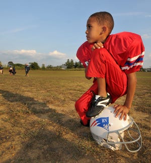 Carmello Anderson, 7, waits for his first football game ever where he will play with his team the RV Patriots. Carmello has cerebral palsy which limits his abilities.