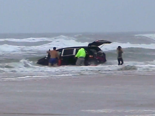 In this image made from video, lifeguards and bystanders rescue children from a minivan that their mother, 31-year-old Ebony Wilkerson, drove into the Atlantic, Tuesday, March 4, 2014 in Daytona Beach, Fla.