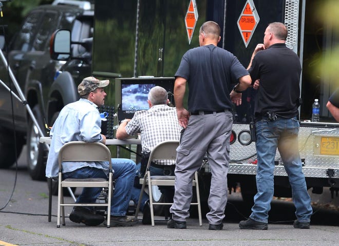 Eugene Police watch the monitor of a remote robot as it searches the scene of a shooting on McLean Blvd in Eugene. (Chris Pietsch/The Register-Guard)