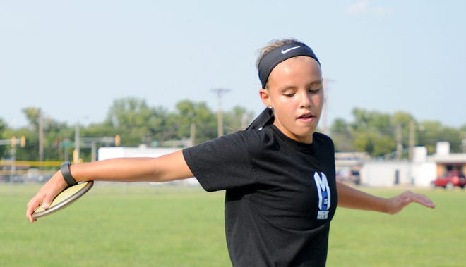 Reagan Geihsler, a seventh-grader at Lakewood Middle School, practices her discus throwing technique Thursday afternoon on the field at Salina Central High School. She recently competed at the USA Track and Field Junior Olympics national championships in Florida, placing second in her age group.