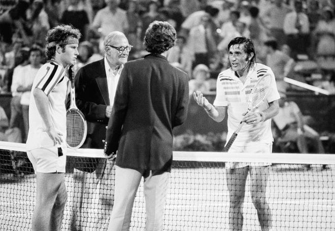 In this Aug 30, 1979 file photo, tournament referee Mike Blanchard, second from left, tries to get the match back underway between John McEnroe, left, and Ilie Nastase, right, during the US Open Tennis Championships in New York. The game referee had awarded one game of the set to McEnroe because Nastase refused to play because of crowd noise.