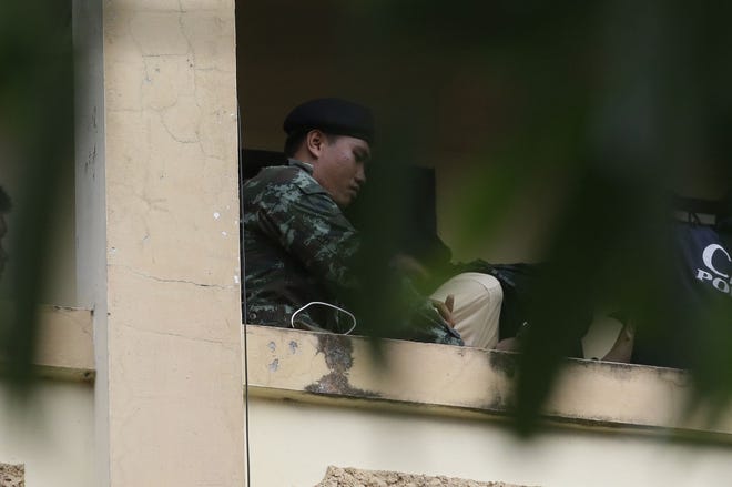 A Thai soldier takes a suspect with a bag on his head out from an apartment on the outskirts of Bangkok on Saturday. The Associated Press
