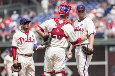 Philadelphia Phillies starting pitcher Alec Asher, right, looks away as catcher Cameron Rupp, center, talks with him as shortstop Freddy Galvis, left, looks on during the first inning of a baseball game against the San Diego Padres, Sunday, Aug. 30, 2015, in Philadelphia. The Padres won 9-4. (AP Photo/Chris Szagola)