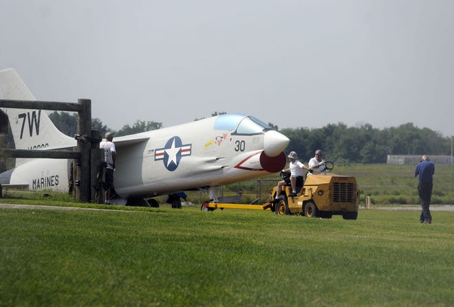 The newly restored F-8 Crusader is towed to new new position at the spot at the Harold F. Pitcairn Wings of Freedom Aviation Museum.