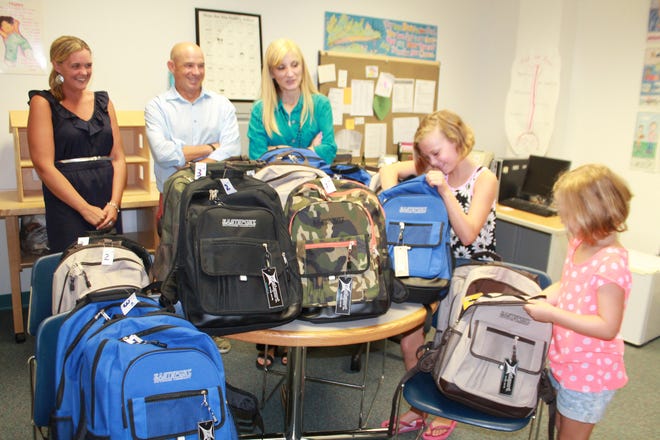 The Philip J. Weihn Youth Foundation recently donated backpacks with school supplies to students at Clinton Hospital. Looking on are (from left) Vice Principal Meghan Silvio, Weighn board members Brian McNally and Angela (Iatrou) Simon while McNally's nieces Catie McNally, 11, and Abby McNally, 8, check out the backpacks. Item photo/JAN GOTTESMAN
