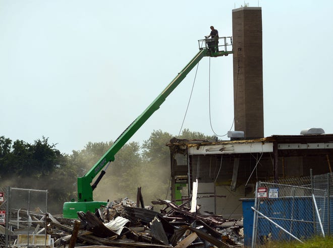 Construction workers demolish part of the old school Monday, Aug. 31, 2015, while the new Tawanka Elementary School is being built on another part of the same property.