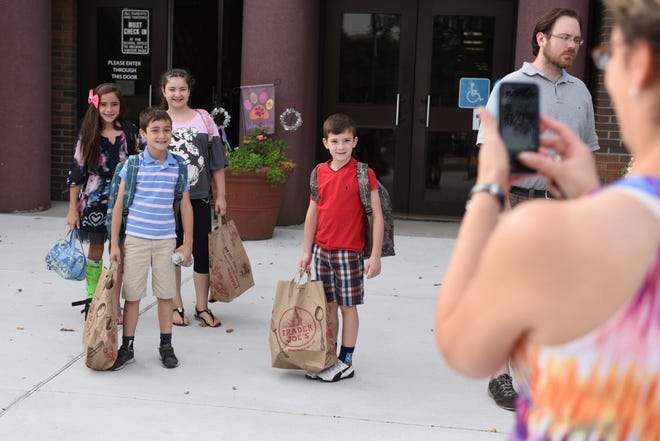 Galina Tsypis takes photos of her children Jacob, Julian and Gabriella, and friend Giavonna as they are dropped at Hillcrest Elementary School Monday
