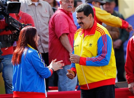 Venezuela's President Nicolas Maduro dances with first lady Cilia Flores during a rally to support the closing of the Colombian border, in Caracas, Venezuela, Friday, Aug. 28, 2015. President Maduro announced that he would extend the week-old partial closure of the border with Colombia to more cities and send additional troops to the area, doubling down on a policy has drawn rebuke by Colombian leaders. (AP Photo/Ariana Cubillos)