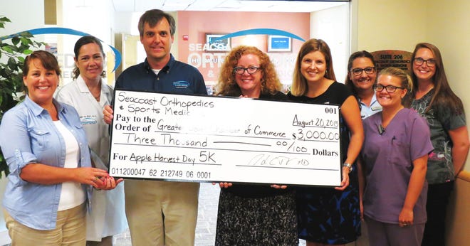 Staff from Seacoast Orthopedics and Sports Medicine present Greater Dover Chamber of Commerce Executive Director Molly Hodgson, with the underwriter check for the 2015 Apple Harvest Day 5k. Photo/courtesy