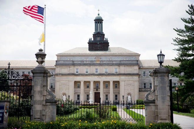 In this June 30, 2015, file photo, flags wave in the wind at the gates of Saint Charles Borromeo Seminary in Wynnewood, Pa. Pope Francis is scheduled to celebrate a Mass at the Saint Martin of Tours chapel at the seminary during his visit to Philadelphia area in September. (AP Photo/Matt Rourke, File)