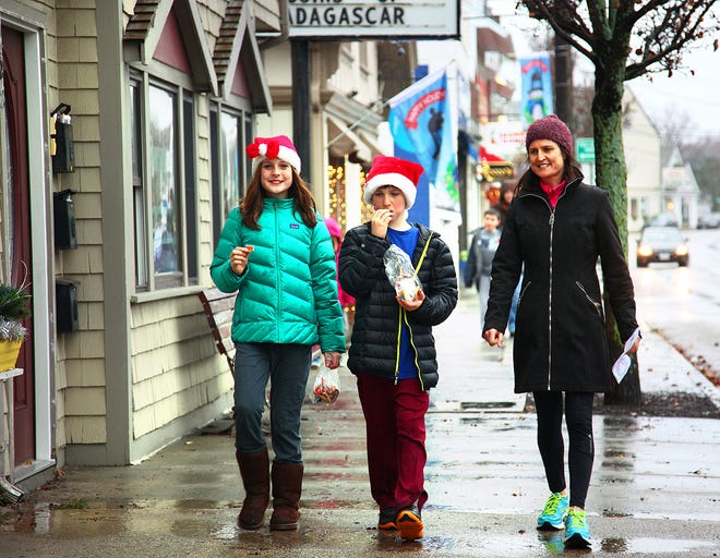 Celia Rees, 11 and brother Jesse, 9, snack on cookies they collected along with their mom, Caroline, at the Scituate Holiday Stroll on Saturday, Dec. 6, 2014.