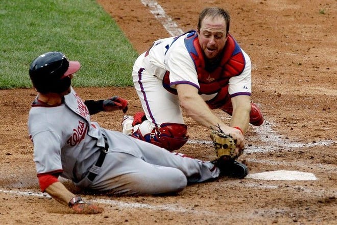 Philadelphia Phillies catcher Erik Kratz, right, tags out Washington Nationals' Stephen Lombardozzi at home after Lombardozzi tried to score on a fielder's choice by Ian Desmond during the seventh inning of the first game a baseball doubleheader, Tuesday, Sept. 20, 2011, in Philadelphia. Washington won 4-3 in ten innings. (AP Photo/Matt Slocum)