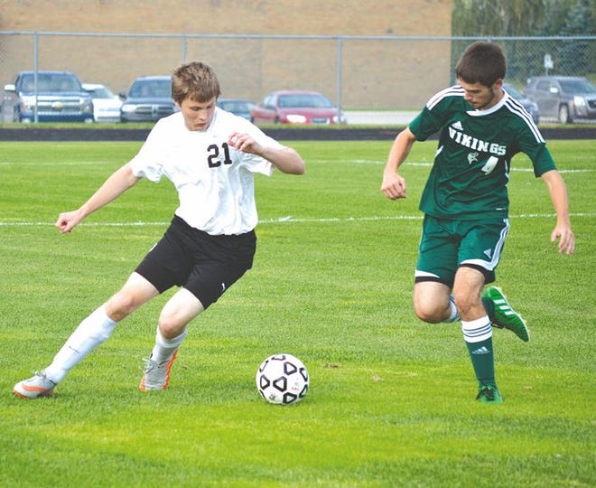 Cheboygan senior defender Brandon St. Clair (21) looks to take possession of the ball in front of Grayling's Darren Johnston during the first half of Tuesday's soccer contest in Cheboygan.