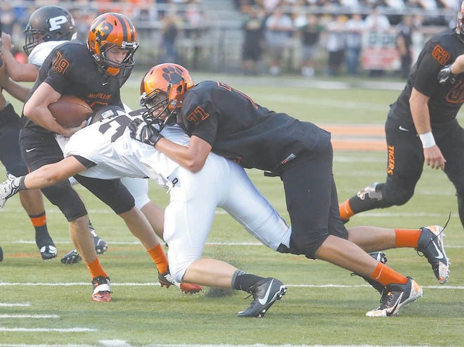 Massillon’s Vincent McConnell attempts to block Perry’s Rece Sabo to open a gap for quarterback Lee Hurst II during Thursday’s game. McConnell was one of four offensive linemen getting his first start.