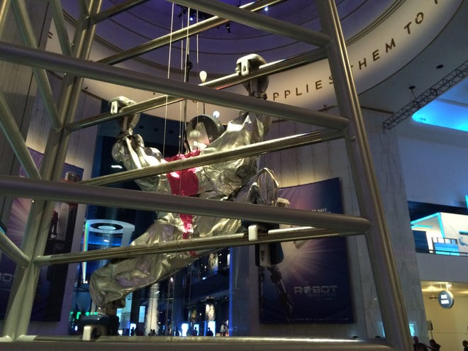 A robot climbs a wire wall in the Museum of Science & Industry.