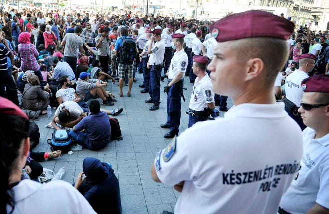 Migrants wait in front of the Keleti Railway Station in Budapest, Hungary, Tuesday, Sept. 1, 2015, after  police stopped them from getting on a train to Germany and evacuated the station. (Tamas Kovacs/MTI via AP)