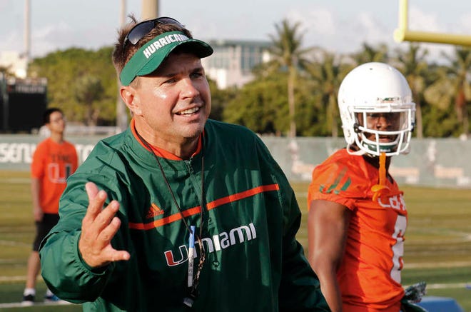 FILE - In this Friday, Aug. 7, 2015 file photo, Miami head coach Al Golden works with his players during an NCAA college football practice in Coral Gables, Fla. The team is not bothered by a national perception that they will struggle this season. Losing Gus Edwards late last month to a season-ending foot injury means there's many more carries up for grabs in a relatively untested Miami backfield. "We don't feel like we're going to miss a beat there," Miami coach Al Golden said Tuesday. "We feel badly for Gus, disappointed for him. He worked really hard but he's coming back, he's in great spirits and it's a great opportunity for the other three guys to step up and execute." (AP Photo/Joe Skipper, File)