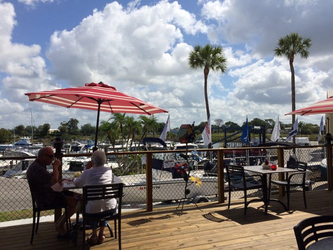 A couple enjoys a deck view of the Marine Max marina Friday during a soft opening at Old Salty Dog before the restaurant officially opens next week.
