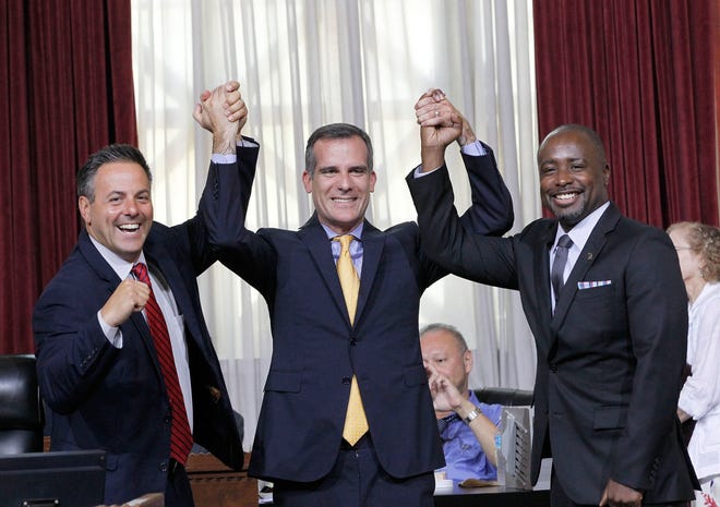 Councilman Joe Buscaino, left, with Los Angeles Mayor Eric Garcetti, center, and Councilman Marqueece Harris-Dawson celebrate after a city council vote in Los Angeles cleared the way for Garcetti to strike agreements for a 2024 Olympics bid. The Associated Press