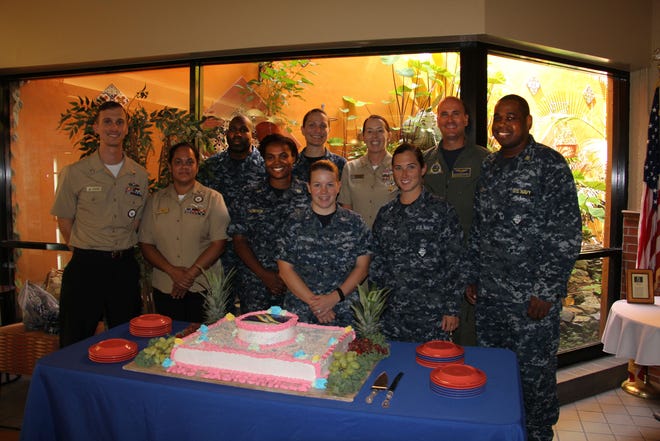 Members of the Multucultural Awareness Committee and NAS Jax command team Commanding Office Capt. Howard Wanamaker and Command Master Chief (AW/SW) Teri McIntyre pose with a special cake made by the galley for the Women's Equality event.