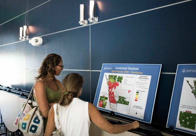 Bettina Jonsef, left, and Edita Lange look at a display during a public information meeting about growth management and funding new schools at Suncoast Technical College on Wednesday.