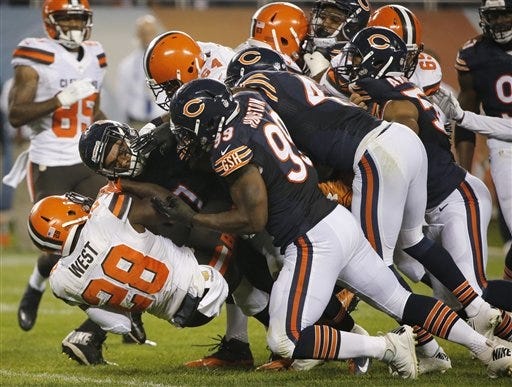 Cleveland running back Terrance West (28) is taken down by the Chicago defense during the first half Thursday in Chicago. CHARLES REX ARBOGAST/THE ASSOCIATED PRESS