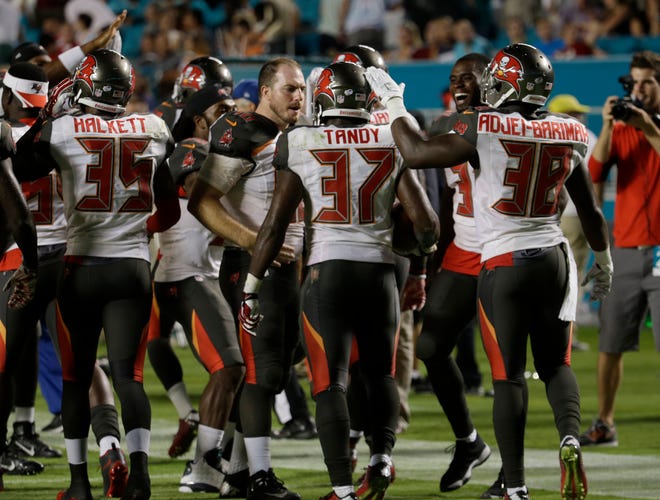 Tampa Bay Buccaneers free safety Keith Tandy (37) is congratulated after he intercepted a pass in the end zone during the second half of an NFL preseason football game against the Miami Dolphins, Thursday, Sept. 3, 2015, in Miami Gardens.