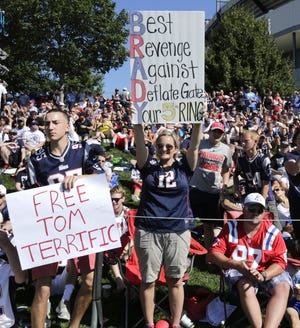 FILE - In this July 31, 2015, file photo, New England Patriots fans hold signs supporting quarterback Tom Brady during a team practice in Foxborough, Mass. A federal judge deflated "Deflategate" Thursday, Sept. 3, 2015, erasing New England quarterback Tom Brady's four-game suspension for a controversy that the NFL claimed threatened football's integrity. U.S. District Judge Richard M. Berman said NFL Commissioner Roger Goodell went too far in affirming punishment of the Super Bowl winning quarterback (AP Photo/Charles Krupa, File)