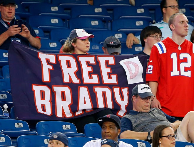 A New England Patriots fan holds a sign referring to Patriots quarterback Tom Brady before Thursday's game. The Associated Press