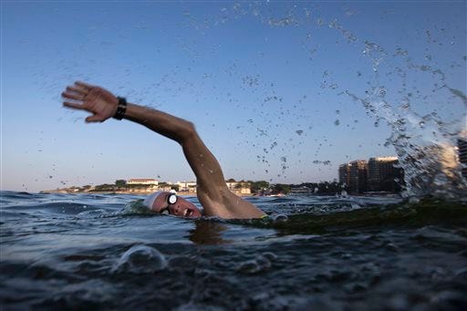 FILE - In this July 31, 2015, file photo, a triathlete swims in the waters off Copacabana beach during training in Rio de Janeiro, Brazil. The World Health Organization's top water expert said Friday, Aug. 14, 2015, the body "never advised against viral testing" for Rio de Janeiro's polluted waterways where about 1,400 athletes will compete in Olympic events next year. Bruce Gordon, the WHO's coordinator of water, sanitation, hygiene and health, told The Associated Press in a phone interview from Geneva that testing for viruses "would be advisable" given it is known that human sewage pollution is rife in Rio's waters. -(]AP Photo/Felipe Dana, File