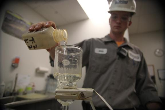 Adam Smith pour filitrated water into a test a tube in prepation for arsenic testing at STEAG. Adam is a part of the apprenticeship program with STEAG through Gaston College.