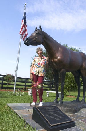Carol Harris poses with the bronze statue of her legendary American quarter horse Rugged Lark at Bo-Bett Farm in Reddick. The statue is being moved to the Florida Horse Park.