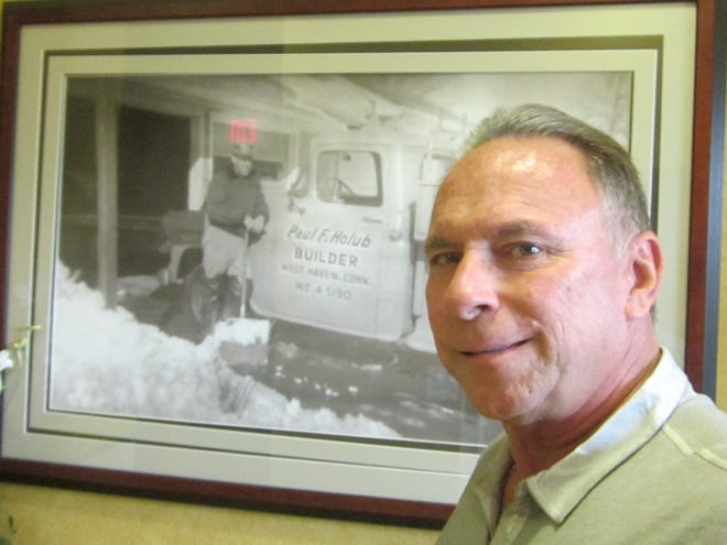 Paul Holub Jr., owner/president of Ormond Beach-based Holub Development, stands in front of a photo of his late father, who ran a residential construction business in West Haven, Connecticut. NEWS-JOURNAL/CLAYTON PARK