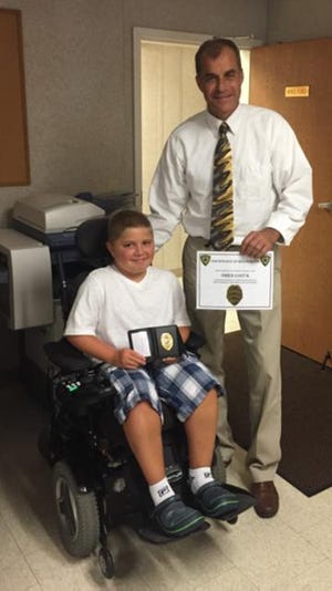Owen Costa, 10, was honored by Dartmouth Police on Monday. He stopped to take a photo with Acting Chief Robert Szala. COURTESY PHOTO