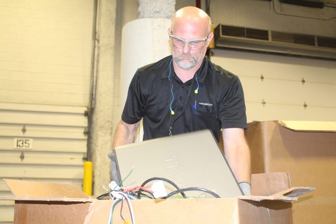 Mark Boerman, recycling center operator at Haworth, sorts electronics and metal materials to be recycled. Justine McGuire/Sentinel staff
