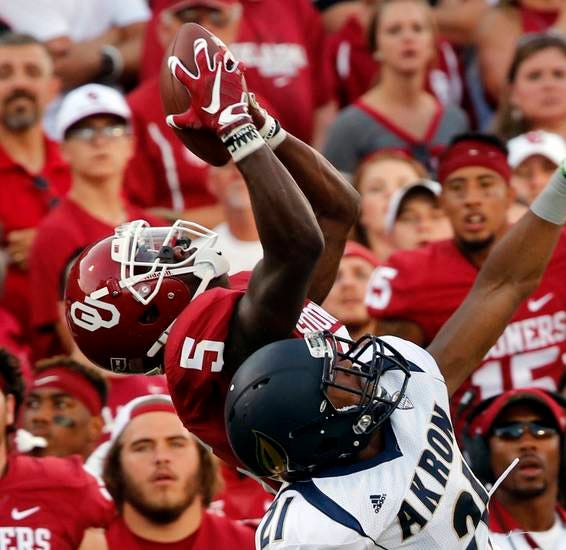 OU's Durron Neal catches a long pass over Akron's Kris Givens in the Sooners' 41-3 rout Saturday night. (Photo by Steve Sisney)