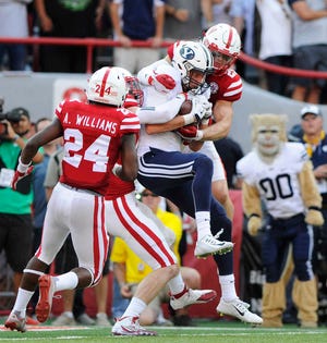 BYU wide receiver Mitch Mathews, center, catches the game-winning touchdown between Nebraska defensive back Aaron Williams (24) and safety Nate Gerry (25) as time runs out in the fourth quarter of an NCAA college football game, to give BYU a 33-28 victory over Nebraska at Memorial Stadium on Saturday, Sept. 5, 2015 in Lincoln, Neb. (Eric Gregory/The Journal-Star via AP) LOCAL TELEVISION OUT; KOLN-TV OUT; KGIN-TV OUT; KLKN-TV OUT; MANDATORY CREDIT