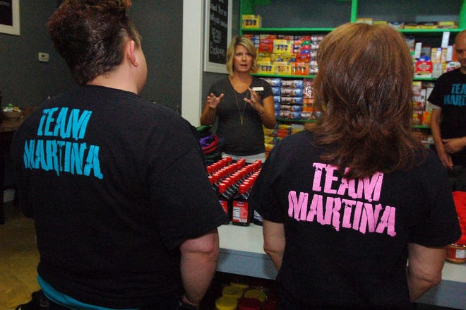 Tiffanie Nelson, center, founder of Food for Thought, shares some information about the charity with members of Martina McBride's charity supporters, Team Martina.