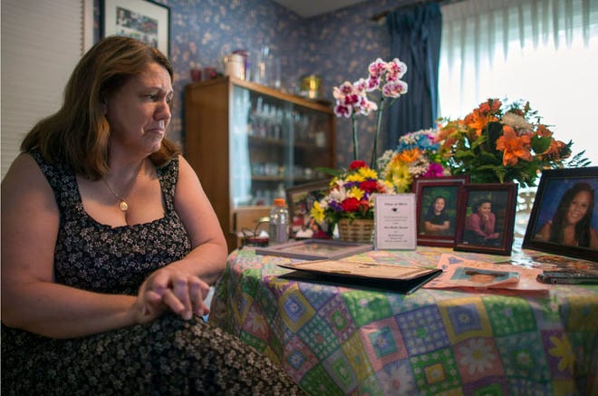 In this Wednesday, Sept. 2, 2015, photo, Dorothy McIntosh Shuemake, mother of Alison Shuemake, looks at a table of pictures and mementos of her daughter, during an interview at her home, in Middletown, Ohio. Alison Shuemake, 18, died Aug. 26, after a suspected heroin overdose. (AP Photo/John Minchillo)
