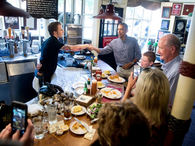 Greets people at Ye Olde Union Oyster House, Monday, Sept. 7, 2015, in Boson. Obama will sign an Executive Order requiring federal contractors to offer their employees up to seven days of paid sick leave per year.